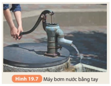Đòn bẩy trong máy bơm nước bằng tay (Hình 19.7) là đòn bẩy loại nào? Sử dụng máy bơm nước này cho ta những lợi ích gì?   (ảnh 1)