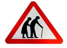 What does this sign mean? A. Be cautious as elderly people may be crossing the road. B. There are two old people here. C. Be careless as elderly people may be crossing the road. D. They are wearing traditional clothing. (ảnh 1)