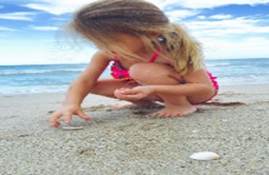 A child in a swimsuit playing on the beach
AI-generated content may be incorrect.