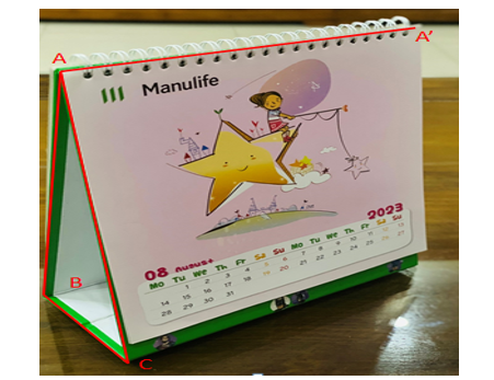 Một cuốn lịch bàn hình lăng trụ đứng có đáy là tam giác \[ABC\] cân tại \[A\] được đặt trên mặt bàn (ảnh 1)